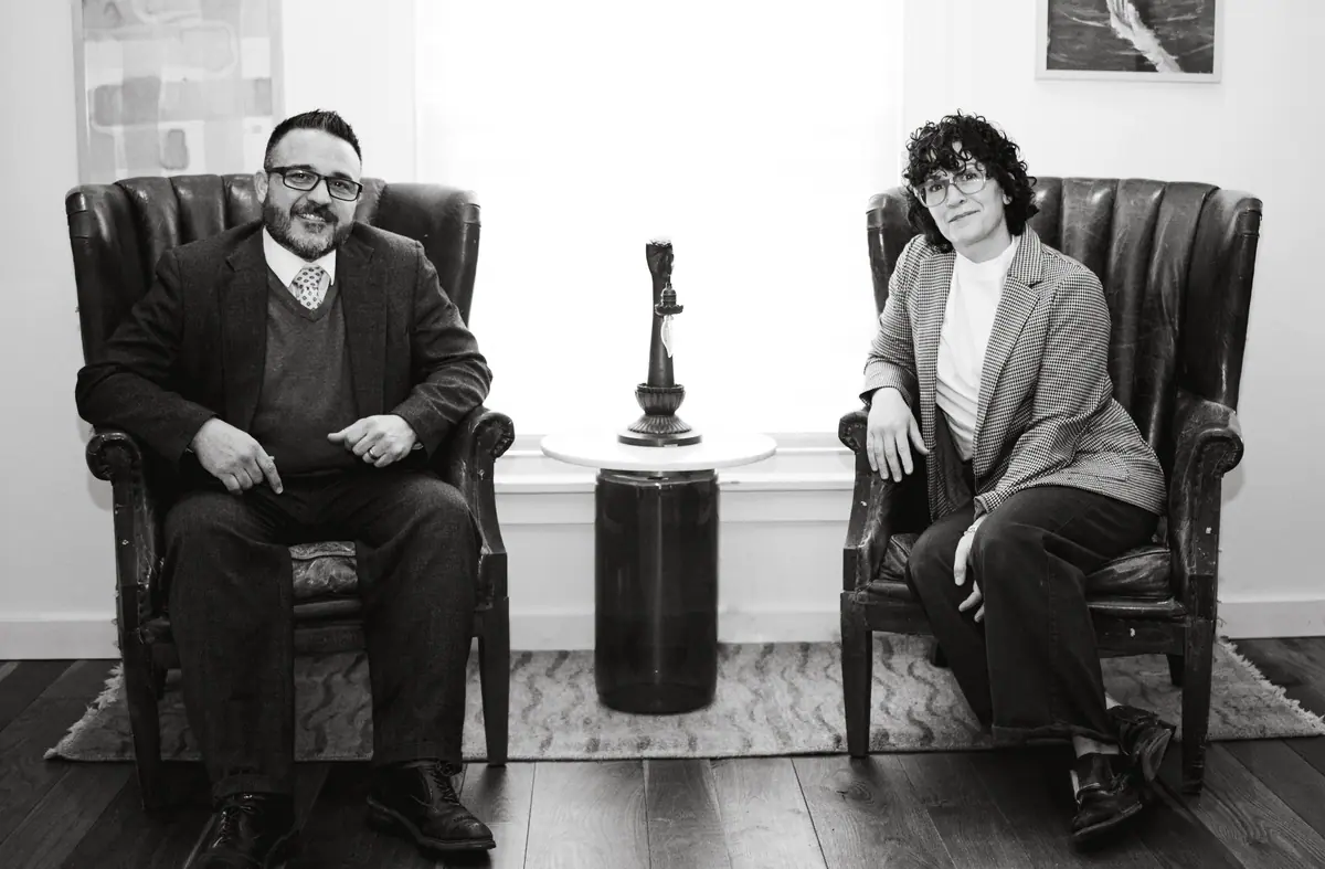 Nicholas and Breonna Frisk seated in leather armchairs in their office